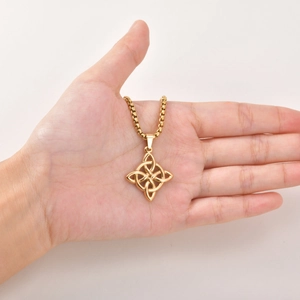 Detailansicht eines goldenen keltischen Knotens an einer Rundboxkette in der Hand