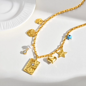 Vue détaillée du collier doré avec pendentifs étoile, cœur, fleur et perle mauvais œil