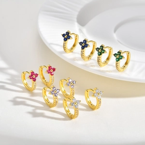 Macro shot of colorful floral hoop earrings with micro zircon inlays and golden bases