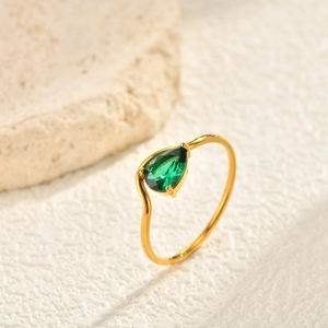 Detailed view of teardrop green zircon stone set in a minimalist gold stainless steel ring