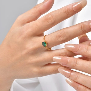 Detailed shot of a gold-plated stainless steel ring with a pear-cut green zircon gem