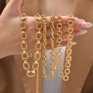 Set of five elegant gold stainless steel necklaces held by a model in a brown suit