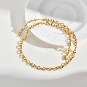 Detail of gold chunky cable chain necklace with K18 engraving and lobster clasp closure