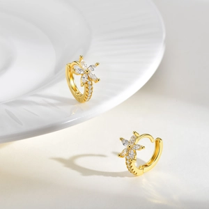 Vue détaillée de boucles d'oreilles fleurs dorées avec zircons taille marquise