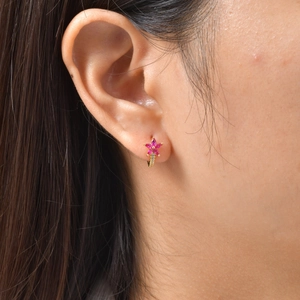 Dettaglio di orecchini a fiore con zirconi rosa e micro cristalli indossati da una modella