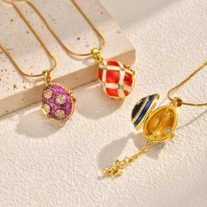 Coffret collier pendentif œuf de style Fabergé doré avec motif ange ouvrant