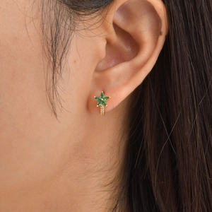 Vue détaillée de créoles fleur avec pierres marquises vertes portées à l'oreille