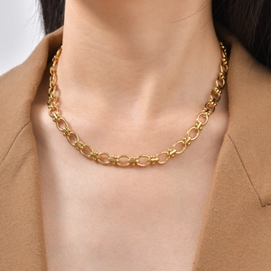 Close-up of golden beaded chain necklace worn on model for an elegant modern style look