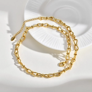 Macro view of gold U-link interlocking chain with adjustable clasp and K18 tag
