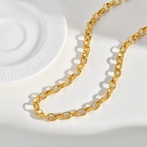 Detailed macro of gold chunky chain necklace with diamond-cut texture and oval links