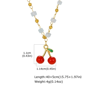 Detalle de collar con cereza roja, cuentas doradas y eslabones cuadrados blancos