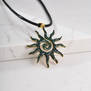 Primer plano detallado del colgante de sol vintage con esmalte verde oscuro y cordón negro