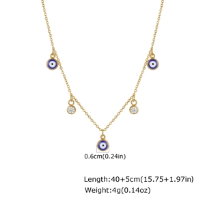 Detalle de collar de acero dorado con colgantes de ojo turco azul y circonitas