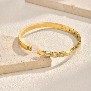 Gros plan du bracelet doré en acier inoxydable avec zircons rectangulaires sur pierre