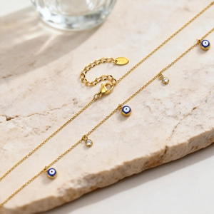 Detalle del collar de ojo turco dorado con esmalte azul y circón sobre superficie de piedra
