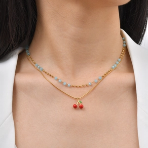 Collana a doppio strato dorata con pendente a ciliegia e perline azzurre da donna