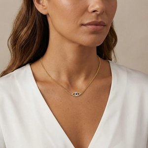 Goldene Halskette mit blauem Auge-Anhänger und Panzerkette an einem Frauenmodell