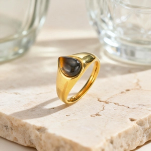 Dettaglio anello vintage in acciaio dorato con pietra occhio di tigre a forma di goccia