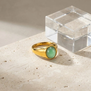 Dettaglio di un anello d'oro vintage con superficie lucida e pietra avventurina verde