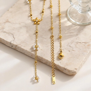 Elegante collana a Y in acciaio dorato con perle a fiore e dettaglio marchio K18
