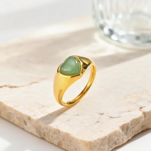 Dettaglio anello dorato con avventurina a forma di cuore su base in pietra naturale