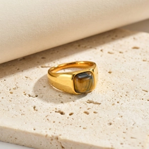 Dettaglio di anello vintage in acciaio dorato con incastonatura quadrata in occhio di tigre