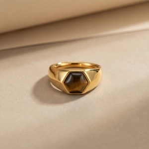 Dettaglio dell'anello a sigillo dorato con castone esagonale in pietra occhio di tigre