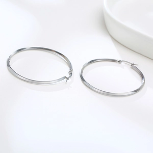 Close-up of silver hoop earrings with flat facet design on a clean white background