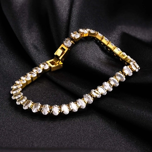 Détail du bracelet tennis doré avec zircons blancs ovales sur fond de soie noire