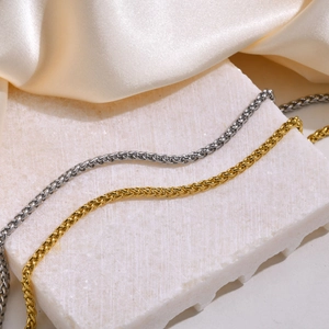 Primer plano de collares de acero inoxidable en oro y plata con textura de malla tejida