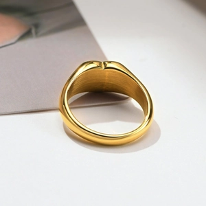 Detailed macro view of gold heart ring showing brushed metal texture and thickness