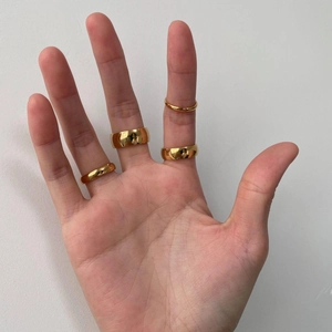 Polished gold tungsten rings in 2mm to 8mm widths shown worn on a hand model