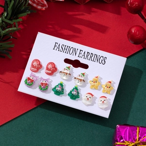 Close-up of festive Christmas earrings set featuring Santa, snowmen, and trees