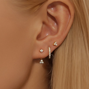 Gouden geometrische oorknopjesset met zirkonia-kristallen gedragen door een model
