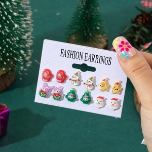Christmas earrings set with cartoon Santa, snowman, and tree motifs on white display card