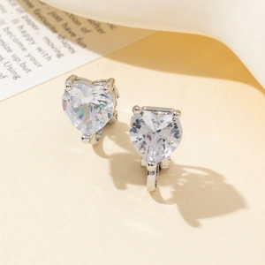 Dettaglio degli orecchini con zircone trasparente a cuore e montatura a tre punte argento