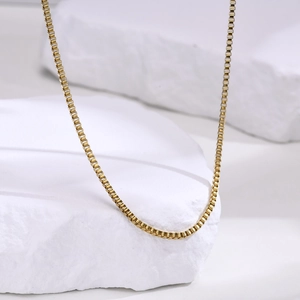 Détail d'une chaîne box de 2mm en acier inoxydable plaqué or 18 carats sur pierre