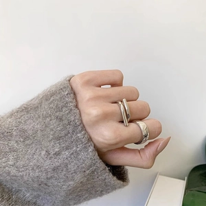 Minimalist silver geometric open rings set worn by a model in a cozy grey sweater
