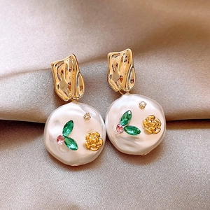 Vintage baroque pearl flower earrings with gold metal and zircon accents on satin