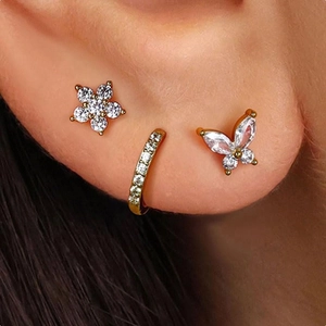 Three-piece gold earring set with zircon butterfly, flower studs and ear cuff