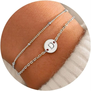 Detail of double-layer stainless steel bracelet with letter D charm on wrist