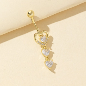 Piercing de ombligo con corazón dorado y circonitas sobre fondo de papel minimalista