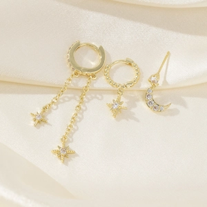 Detailed view of gold earrings set featuring stars and moon charms with zircon stones