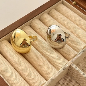Minimalistische dicke gewölbte Metallringe in Gold und Silber auf einem Schmucktablett