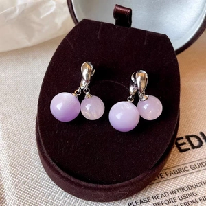 Détail de boucles d'oreilles double perle violet clair avec crochets en argent