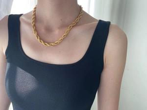 Close-up of a thick 8mm twisted rope chain necklace in 18K gold finish on a female model