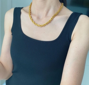 Detail of 8mm gold rope chain necklace on model for a bold fashion jewelry look