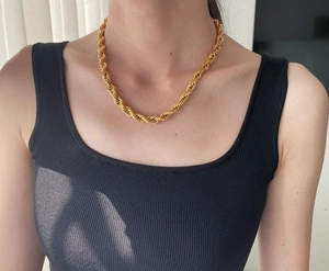 Close-up of a 18K gold-plated 8mm rope chain necklace on a model's neck