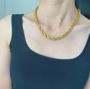 Close-up of 8mm golden twisted rope chain necklace worn on a woman's collarbone