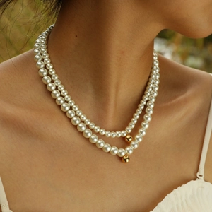 Elegante doppelreihige weiße Perlenkette mit zwei polierten goldenen Kugelanhängern